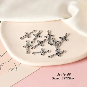 Antique silver cross alloy pendants 12x22mm for DIY jewelry making displayed on ceramic tray