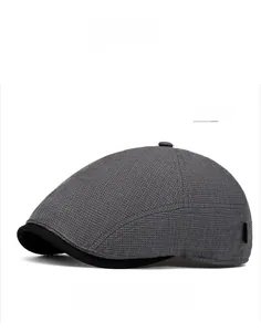 Detail of grey textured knit ivy cap with contrasting black brim and fine check pattern