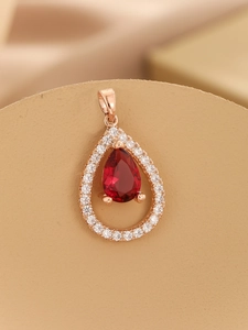 Detailed macro view of pear-cut red gemstone pendant set in rose gold with zircon accents