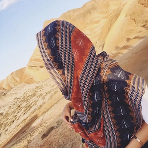 Ethnic embroidered cotton linen scarf with tassels displayed in a desert setting