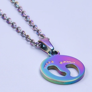 Close-up of rainbow gradient stainless steel necklace with hollow circular footprint charm