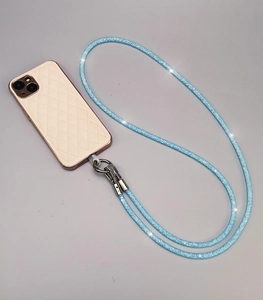 Detail of blue glitter phone crossbody strap with silver metal clasp on gold case