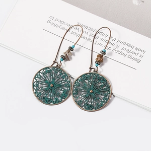 Bohemian vintage hollow geometric earrings with blue and brown beads on a white card