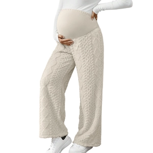 Macro detail of beige maternity knit trousers showing thick cable knit texture and fabric
