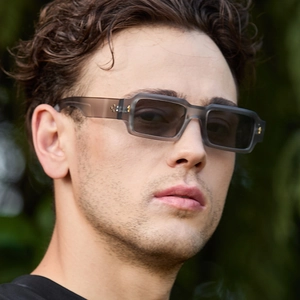 Fashionable grey translucent rectangular sunglasses with metal rivets on female model