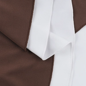 Close-up of brown and white spliced fabric texture with high-density stitching details