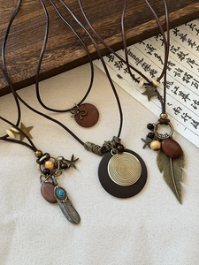 Macro view of retro leather star and feather tassel necklace with wooden accents