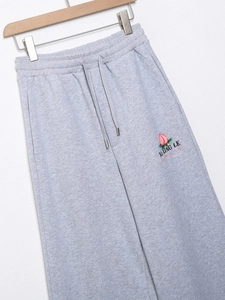 Détail du pantalon de jogging gris avec broderie pêche et taille à cordon