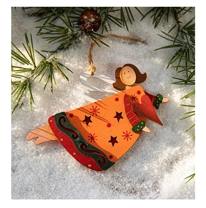Close-up of wooden angel Christmas ornament with heart patterns on a snowy background