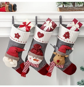 Trois chaussettes de Noël festives avec Père Noël 3D suspendues à une cheminée