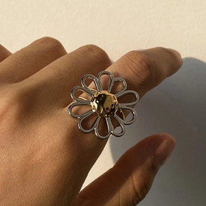 Detailed view of bicolor daisy ring with silver petals and golden hammered center texture