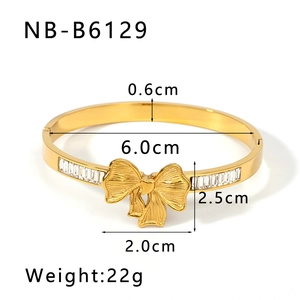 Detailed view of gold bow bangle with dimensions showing 6.0cm diameter and zircon inlay