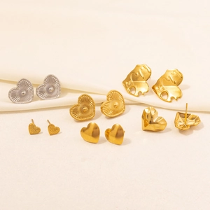 Detailed view of six pairs of heart-shaped earrings in gold and silver metal finishes