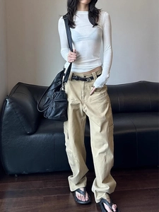 Slim fit white long sleeve top paired with khaki cargo pants and a black tactical bag