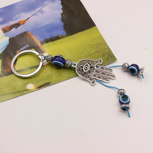 Detailed view of Hamsa hand keychain with blue evil eye beads and silver alloy patterns