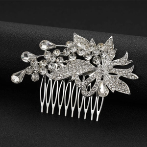 Dettaglio ravvicinato di un pettine per capelli da sposa in argento con strass e foglie