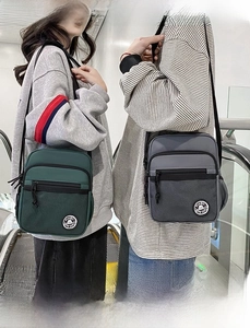 Macro detail of high-quality nylon crossbody bags in dark green and grey with dual zippers