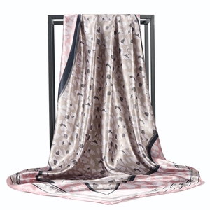 Elegant leopard print silk satin square scarf in beige and pink on a black metal stand