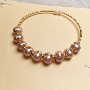 Detail of 14K gold-wrapped freshwater pearl open cuff with pink and purple pearls