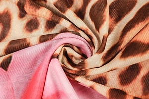 Dettaglio del tessuto mesh rosa cucito con stampa leopardata e pieghe a spirale eleganti