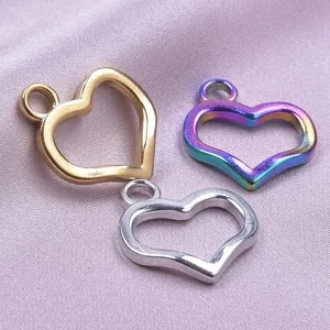 Macro shot of heart-shaped hollow metal pendants in gold, silver, and rainbow on silk