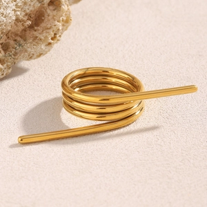 Detailaufnahme von 18K vergoldetem Edelstahl-Spiralring auf einem beigen Hintergrund