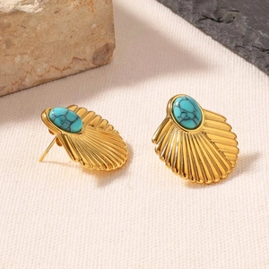 Detailed view of fan-shaped titanium steel earring with turquoise inlay and brushed gold finish