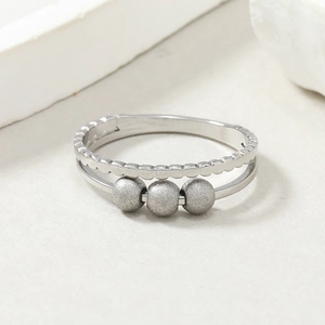 Macro detail of silver double-layered titanium steel ring with rotating frosted beads