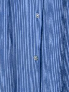 Détail de la texture rayée bleue avec des boutons nacrés sur un chemisier décontracté