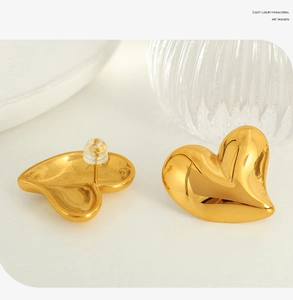 Vue détaillée de boucles d'oreilles cœur en or poli avec fermoirs de sécurité