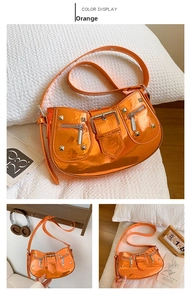 Close-up of bright orange glossy patent leather bag with silver studs and Y2K buckles
