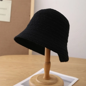 Close-up of black knitted bucket hat showing thick wool texture and warm winter design