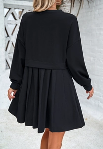 Détail du panneau plissé au dos et des coutures contrastées de cette robe noire à manches longues