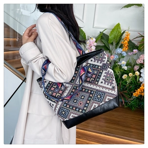 Ethnic bohemian tote bag with woven geometric pattern and black leather base detail