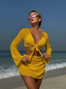 Dettaglio del set da spiaggia giallo brillante con top in rete e minigonna in rete coordinata