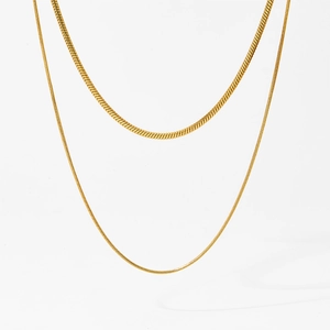 Close-up of double-layered gold snake chain necklace with high-gloss metallic finish