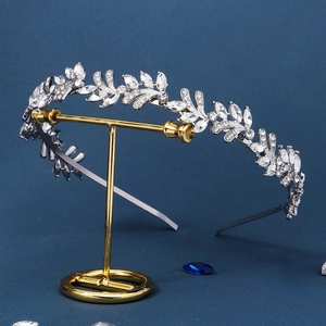 Close-up of leaf-shaped silver headband with sparkling rhinestones on display stand