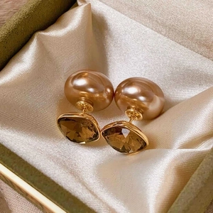 Elegant 18k gold plated pearl flower earrings with amber gemstones on silk background