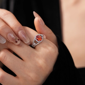 Macro shot of oval orange-red gemstone ring with micro-pave white cubic zirconia