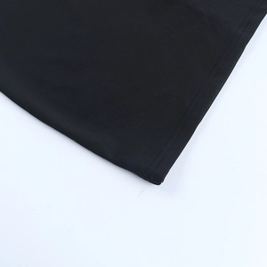 Détail de la couture à double ourlet sur le tissu élastique noir de la robe