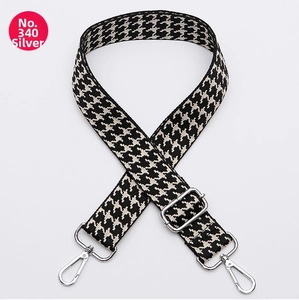 Detail of adjustable silver buckle and black and white houndstooth woven strap texture