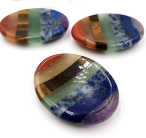 Detailed macro view showing the 7 Chakra layered crystals with a polished smooth oval finish