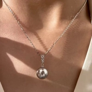 Detail of a 6-7mm grey freshwater pearl pendant necklace on a delicate silver chain