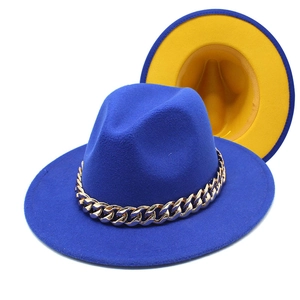 Detail of blue and yellow fedora hat with a chunky gold acrylic chain accessory