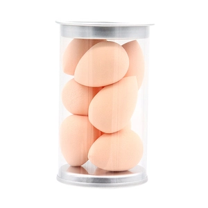 Macro detail of mini teardrop makeup sponges in a clear jar with a metallic silver lid