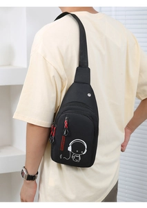 Rear view of black nylon crossbody bag with luminous astronaut print on model