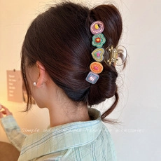 Detailed view of an acrylic triangle hair claw clip with colorful 3D cartoon charms