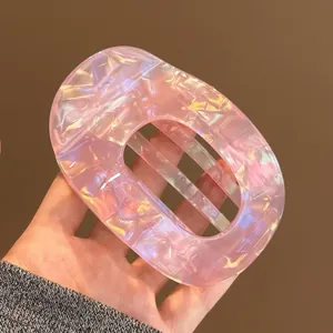 Detailed view of pink iridescent acetate duckbill hair clip with hollow oval design, 10cm