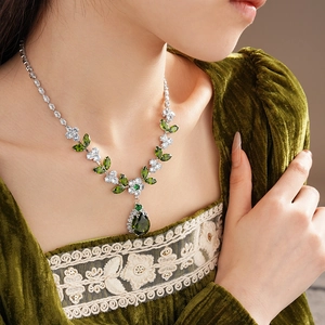 Detail of silver leaf necklace featuring green waterdrop zircon on elegant velvet top