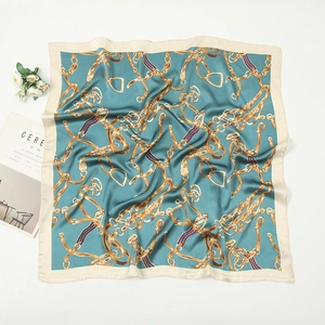 Detailed pattern of teal silk square scarf with golden horsebit and chain motifs
